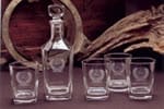 A group of glass bottle and small cups, all etched
